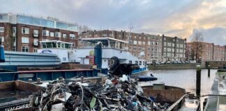 Berg bagger met rommel van bodem De Wittenkade