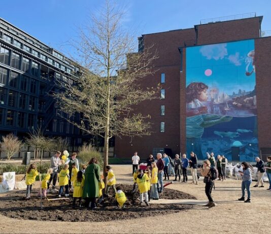 Kinderen helpen bij planten eik in nieuw parkje in Houthaven