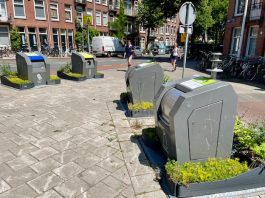 Plantjes in plaats van rommel naast afvalcontainers